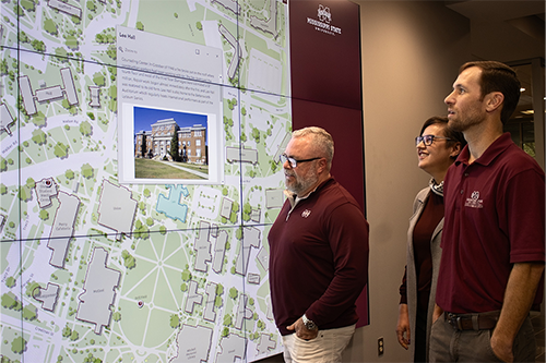 MSU Geosystems Research Institute Assistant Extension Professor John Cartwright, front, along with GRI Research Associate Kate Grala and GRI GIS Coordinator Andrew Nagel view the new interactive campus map built by the researchers